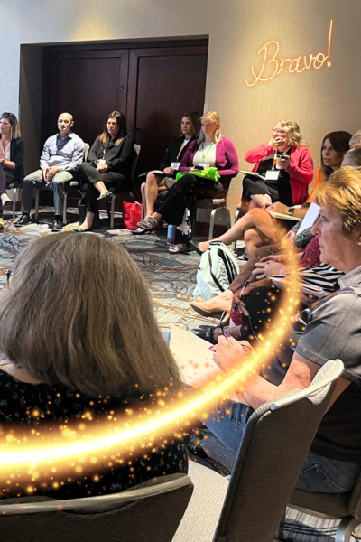 A group of professionals sitting in a circle discussing solutions and innovation in community-based child welfare at the annual symposium hosted by the National Center. 