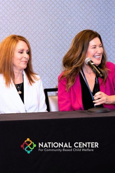 A professional giving a speech to other professionals at the community-based child welfare annual symposium hosted by the National Center for Community-Based Child Welfare. 