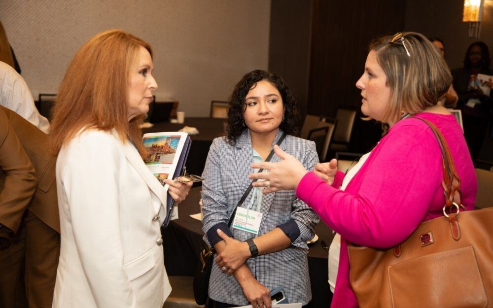  Two attendees at the National Center for Community-Based Child Welfare’s 2024 National Symposium network with Secretary Paula Fleming.